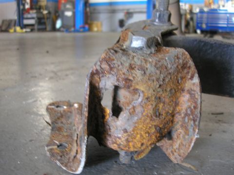 1995 Ford Bronco - This heavily corroded metal component shows significant wear and tear, indicating a need for replacement.