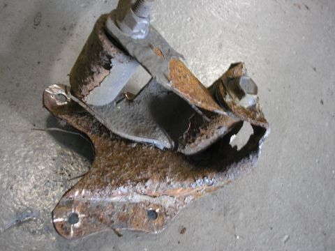 1995 Ford Bronco - A heavily corroded metal bracket, likely a vehicle part, shows significant rust and damage.