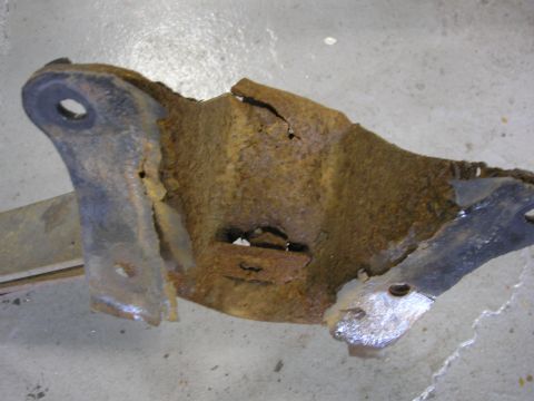 1995 Ford Bronco - This heavily corroded metal bracket shows significant damage and wear.
