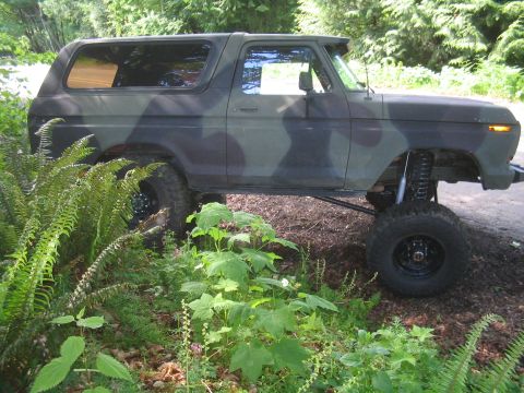 1979 Ford Bronco - This lifted 1979 Ford Bronco features a camouflage paint scheme and is seen parked in a wooded area.