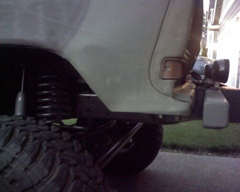 1979 Ford Bronco - Close-up of an off-road vehicle's suspension and tire, showing aftermarket modifications.