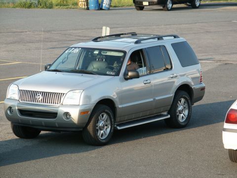 2001 Mercury Grand Marquis - A silver Mercury Mountaineer is seen from the front-right side, with another vehicle partially visible on the right.