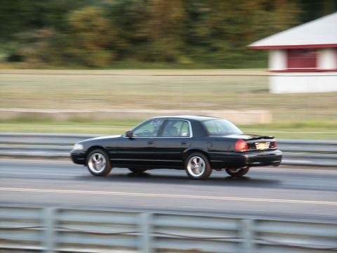 2001 Mercury Grand Marquis - Black 2001 Mercury Grand Marquis captured in motion on a drag strip with a building in the background.
