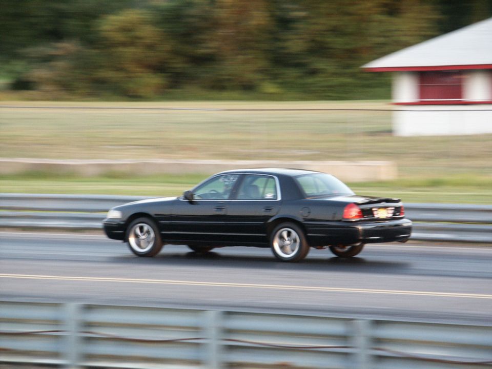 Black 2001 Mercury Grand Marquis driving on a drag strip