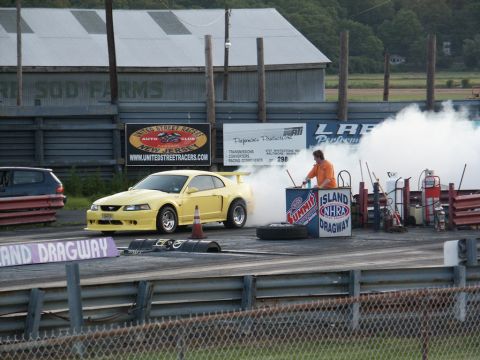 2001 Mercury Grand Marquis - A yellow Ford Mustang performs a burnout at Island Dragway, creating a large cloud of smoke.
