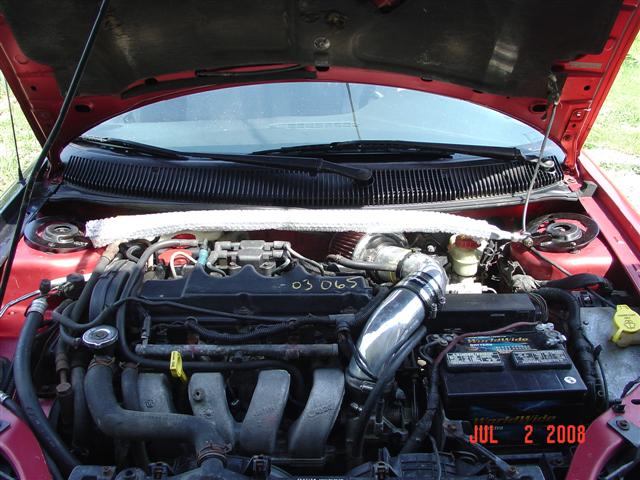 Red 1997 Dodge Neon engine bay with aftermarket intake and strut bar