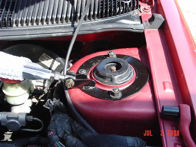 Red engine bay with strut mount and brake fluid reservoir