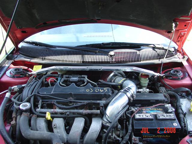 Red engine bay with chrome strut bar and aftermarket air intake
