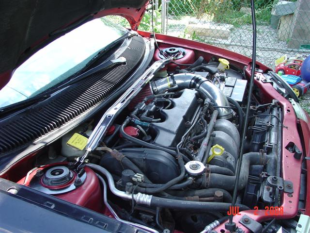 1997 Dodge Neon engine bay with aftermarket intake and strut bar