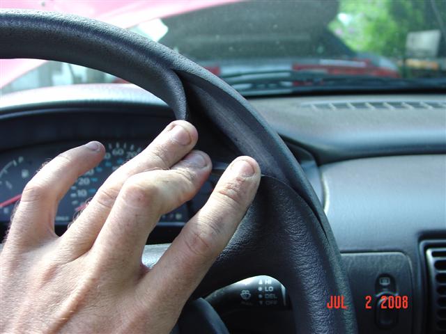 1997 Dodge Neon interior with a hand on the steering wheel and dashboard visible