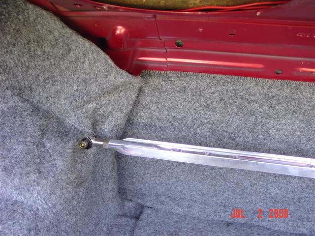Trunk interior with gray carpet and a silver strut bar