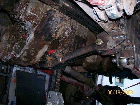 1984 Ford Bronco - Undercarriage components including transfer case and suspension parts are visible, supported by a jack stand.