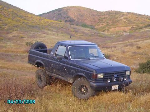 1990 Ford Bronco - This Ford Bronco is shown off-road with a spare tire mounted on the rear.