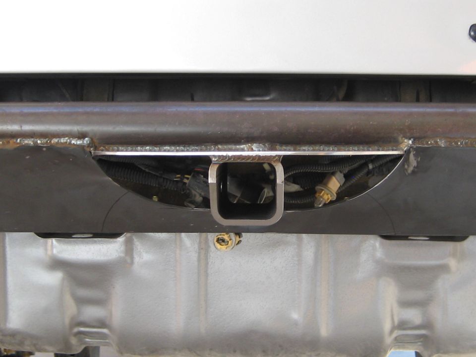 Trailer hitch receiver with wiring harness visible behind it