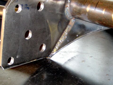 1996 Ford Bronco - A close-up view of a fabricated metal part, showing drilled holes and expertly applied welds.