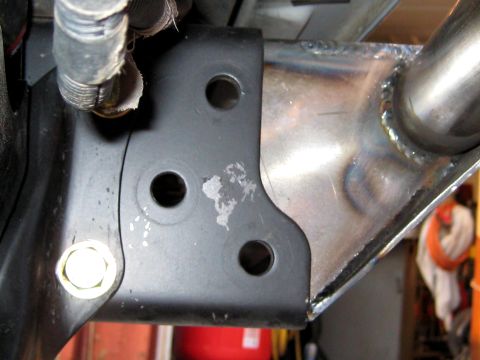 1996 Ford Bronco - This is a close-up view of a vehicle's frame bracket, showing its mounting points and a bolt.