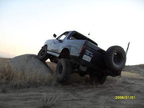 1990 Ford Bronco - A 1990 Ford Bronco navigates a rocky incline, its off-road capabilities.