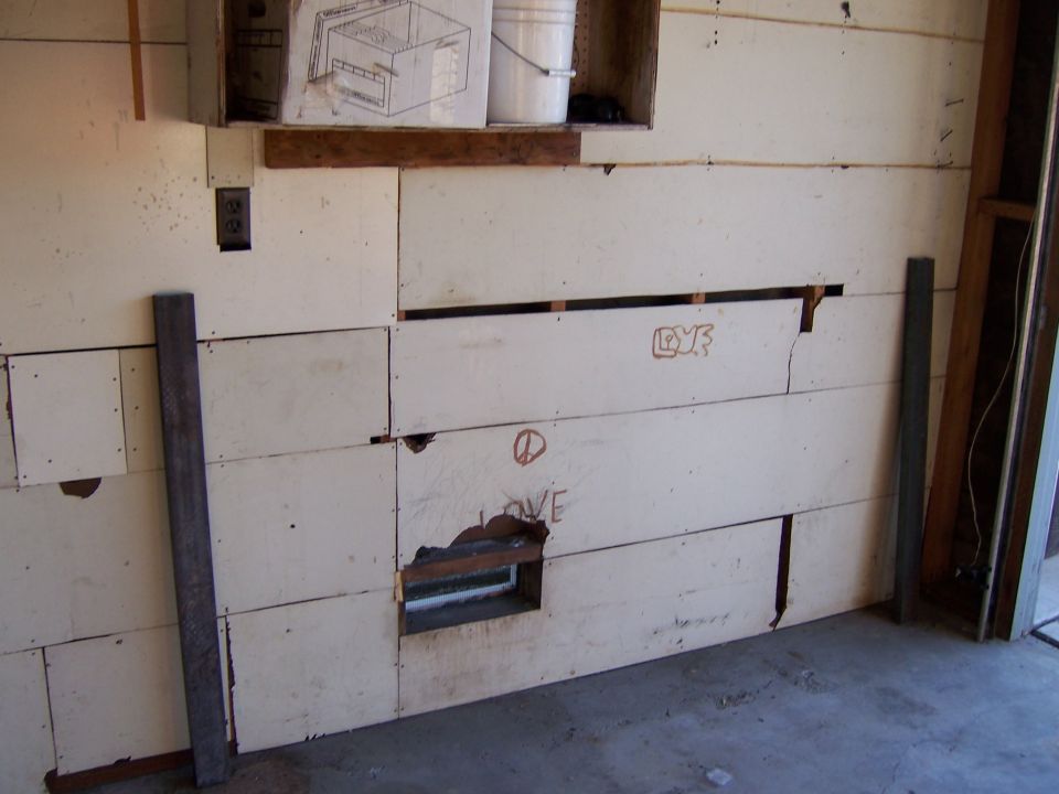 Interior wall with panels, some damaged. Graffiti includes 'LOVE' and a peace sign