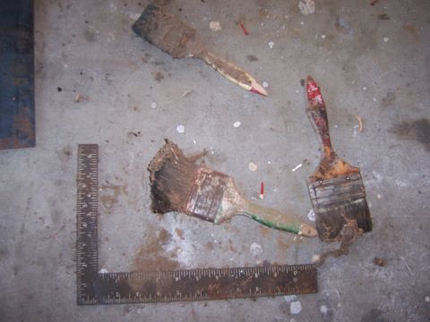 1991 Ford Bronco - Three used paint brushes and a metal ruler are scattered on a concrete surface, suggesting a work area.