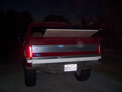 1991 Ford Bronco - Rear view of a 1991 Ford Bronco, carrying a piece of wood in its bed.