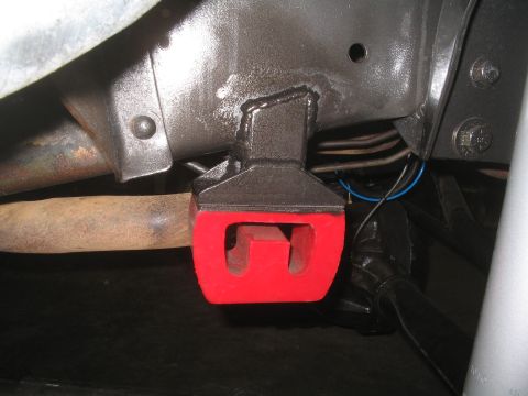 1979 Ford Bronco - This photo shows a close-up of a vehicle's undercarriage, focusing on a red polyurethane bushing attached to the frame.