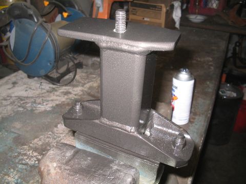1979 Ford Bronco - A fabricated metal bracket, likely for automotive use, is secured in a vise on a workbench.
