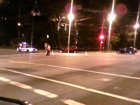 1989 Ford Bronco - A traffic accident scene unfolds at an intersection, with an overturned vehicle and a police car present.
