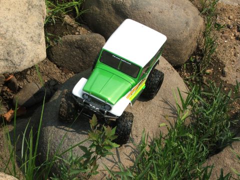 1996 Ford Bronco - RC rock crawler toy truck with 'TEAM NOVAK' decal on windshield sits on rocks.
