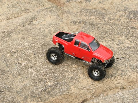 1996 Ford Bronco - A red remote control pickup truck navigates a rocky terrain, its off-road capabilities.