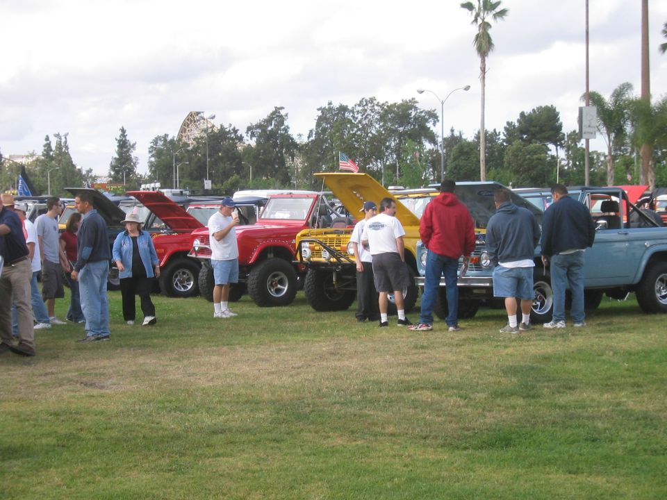 Crowd browsing lifted Broncos and trucks at a car show