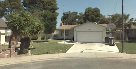 1991 Ford Bronco - A suburban house with a garage, driveway, and a basketball hoop in the yard. The house number 666 is visible on the garage door.