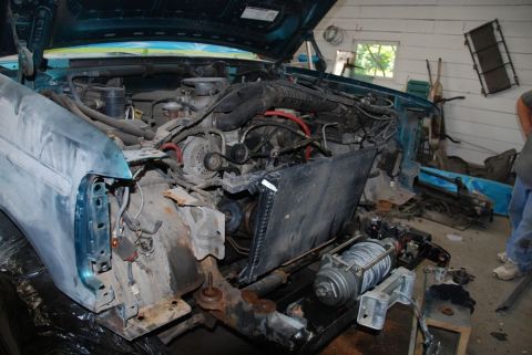 1996 Ford Bronco - The engine bay of a vehicle is exposed, with the radiator and other components disassembled for repair or maintenance.