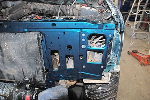 1996 Ford Bronco - Close-up view of a vehicle's core support and radiator, painted teal, with engine parts visible above.