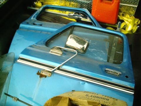 2001 Dodge 2500 - Two blue truck doors are stacked and appear to be parts for a restoration project.