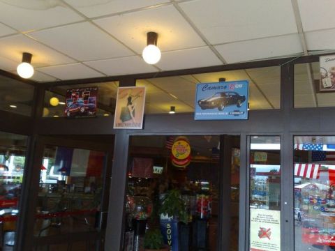 1991 Ford Crown Victoria - Interior view of a building with car posters and flags displayed near the entrance.