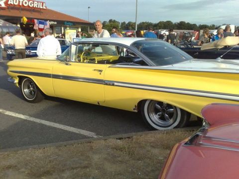 1991 Ford Crown Victoria - A classic yellow and white car is seen at an outdoor car meet with other vehicles present.