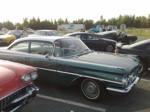 1991 Ford Crown Victoria - A classic green and white car is parked at an outdoor car meet with other vehicles visible.