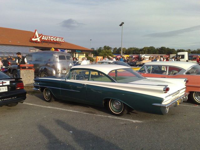 1959 Oldsmobile Ninety-Eight two-door hardtop coupe, green and white, parked next to other classic cars