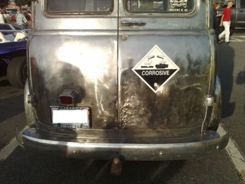1991 Ford Crown Victoria - This vintage van displays a corrosive hazard sticker and a license plate frame indicating '1949'.
