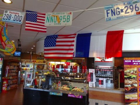 1991 Ford Crown Victoria - A store interior decorated with patriotic and state license plates, along with American and French flags.
