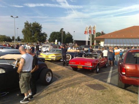 1991 Ford Crown Victoria - A gathering of classic cars and people under a partly cloudy sky.