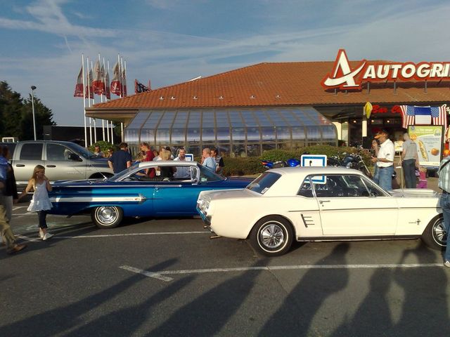 White 1965 Ford Mustang coupe parked next to a blue car