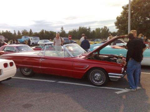 1991 Ford Crown Victoria - A red convertible is displayed with its hood open at an outdoor car meet.