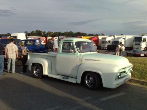 1991 Ford Crown Victoria - A classic two-tone pickup truck is parked at an outdoor event with other vehicles and trucks in the background.