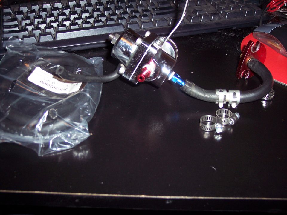 Chrome fuel pressure regulator with black hose and red fittings