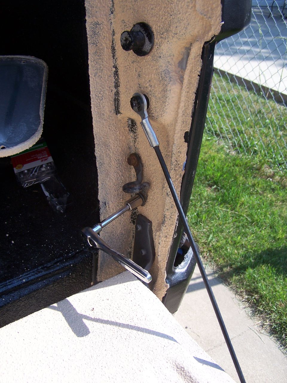 close-up of tailgate latch being worked on with a socket wrench
