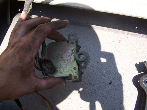 1986 Ford Bronco - A hand holds a Singer 60A electrical component, likely from a vehicle.