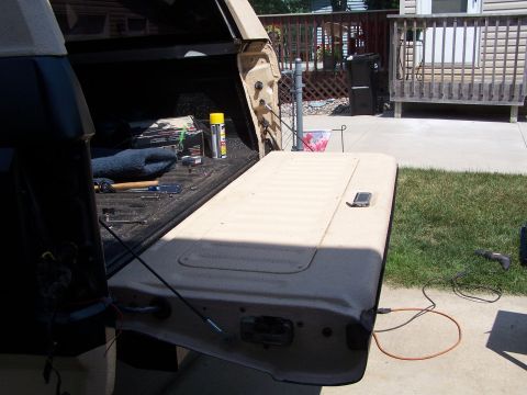 1986 Ford Bronco - Tools and supplies are visible in the bed of a pickup truck with the tailgate down.