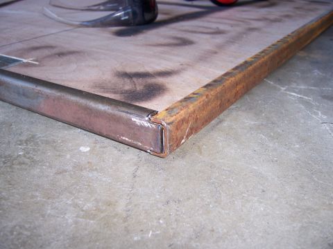 1991 Ford Bronco - A close-up view of a metal frame being constructed on a wooden surface.