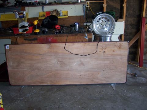 1991 Ford Bronco - Workbench in a garage setting with various tools and a car wheel on display.